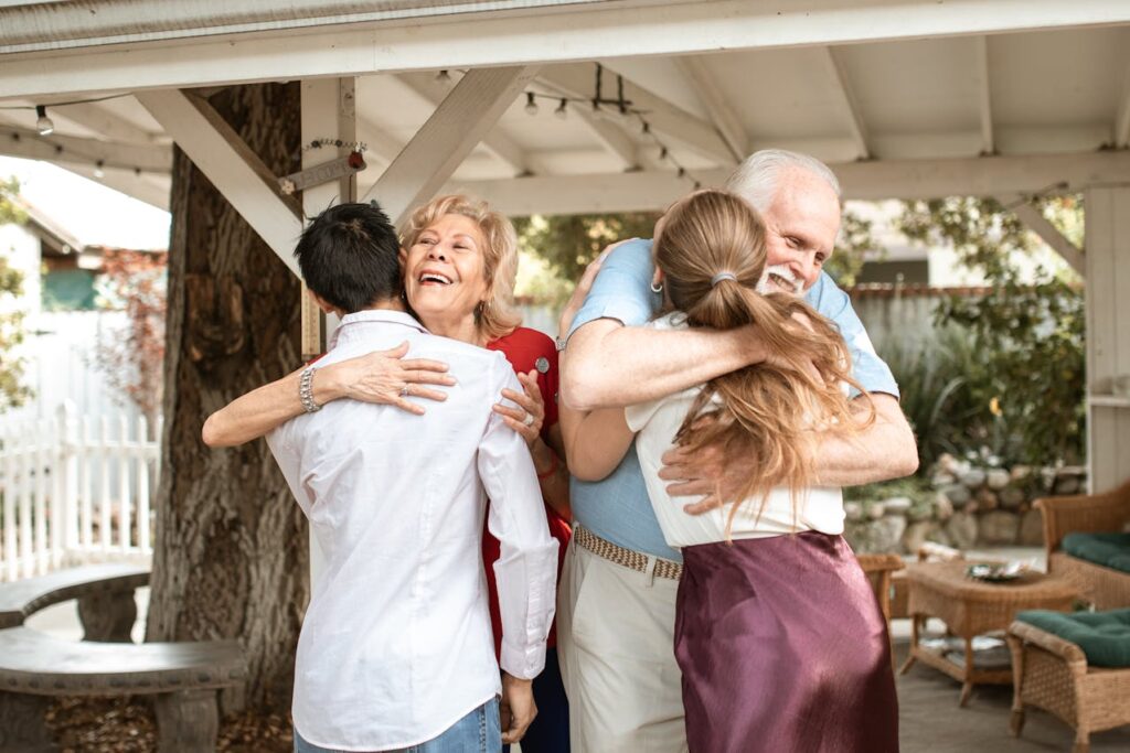Elderly couple embracing their adult children.